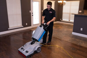 technician cleaning hardwood floor