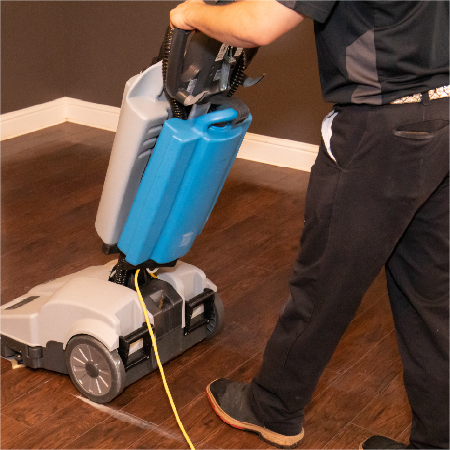 Hardwood DT Technician cleaning Hardwood floor with a scrubbing machine