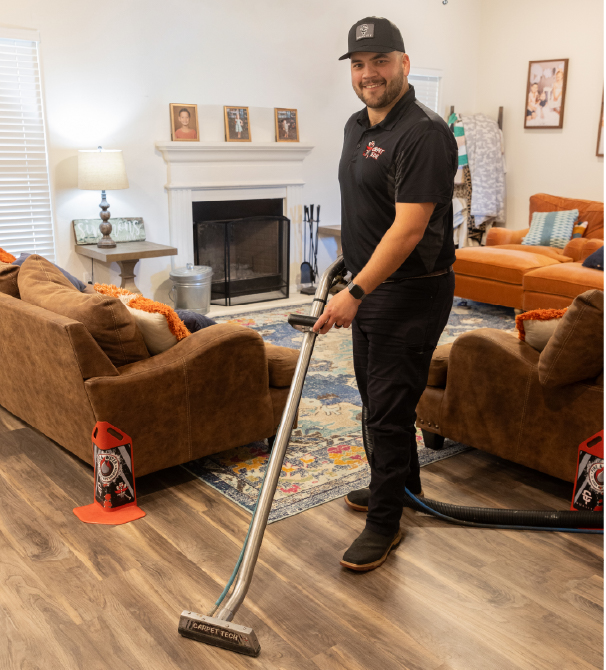 Cade Simmons, San Angelo Site Manager, cleaning a hardwood floor with a wand.